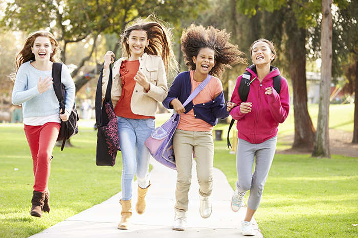 Group Of Young Girls Running Towards Camera In Park